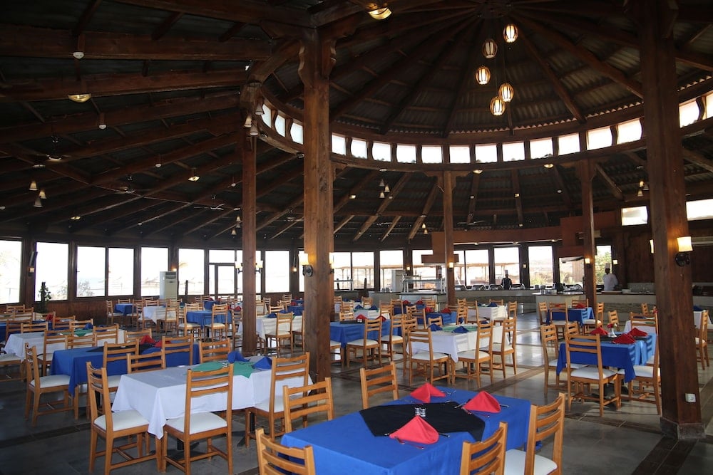 Laguna Beach Marsa Resort restaurant with a timber-beamed ceiling and surrounding windows.