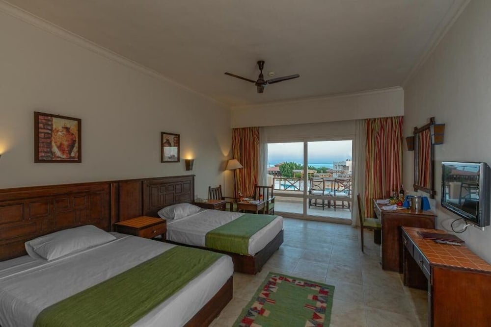 Laguna Beach Marsa Resort twin bedroom with two beds and balcony access.