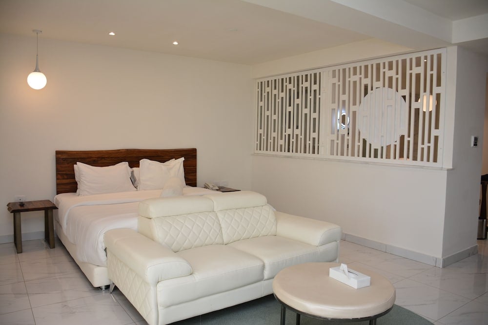 Steigenberger Pure Lifestyle (Adults Only) bedroom with a bed and a sofa.