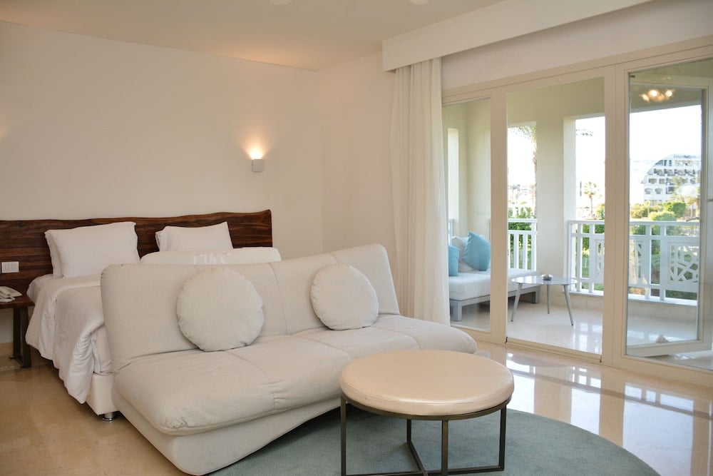 Steigenberger Pure Lifestyle guest room with a white sofa and glass balcony doors.