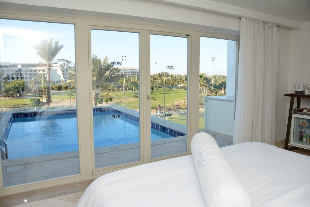 Steigenberger Pure Lifestyle (Adults Only) bedroom with large windows and a pool view.