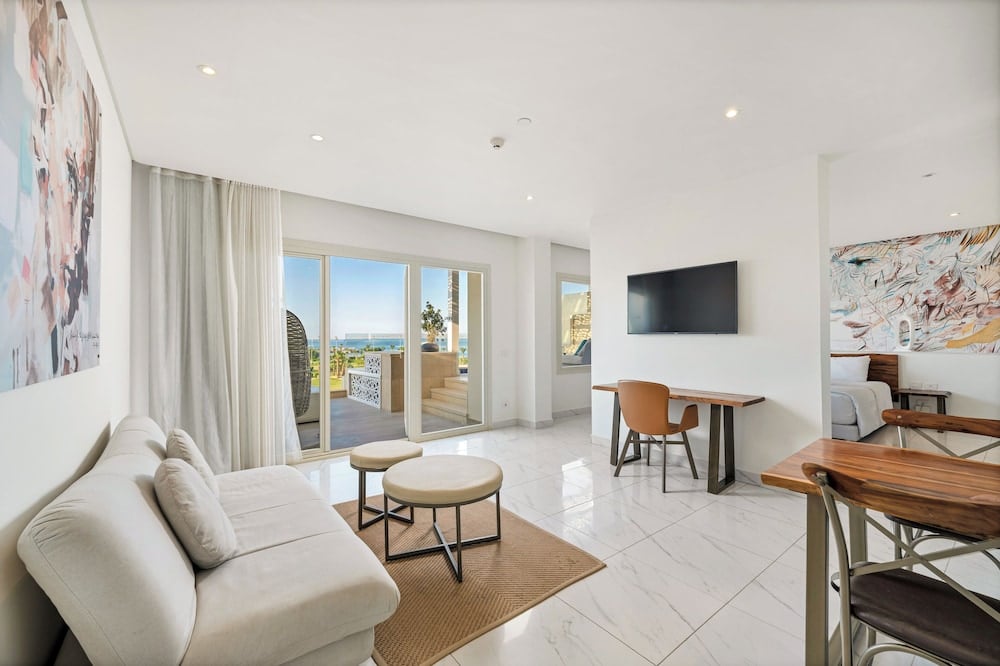 Steigenberger Pure Lifestyle (Adults Only) suite living area with a sofa and sliding glass doors.