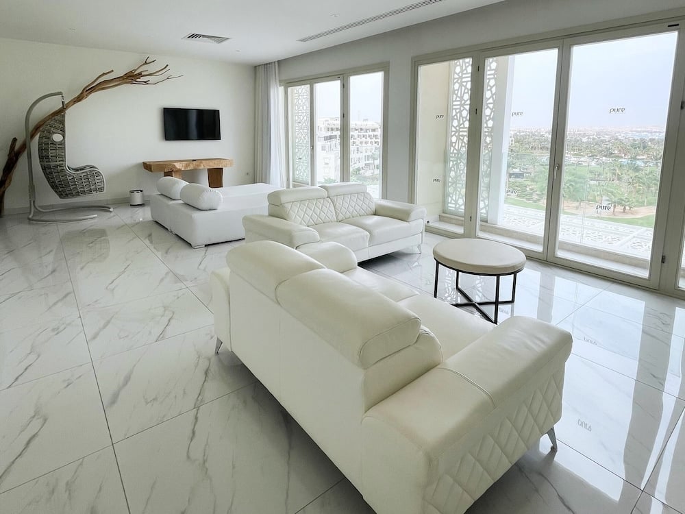 Steigenberger Pure Lifestyle (Adults Only) living room with white sofas and floor-to-ceiling windows.