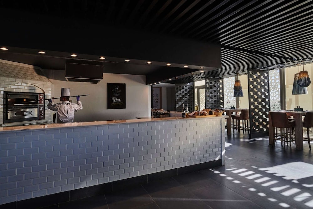 Steigenberger Pure Lifestyle (Adults Only) restaurant with a tiled counter and dining tables.