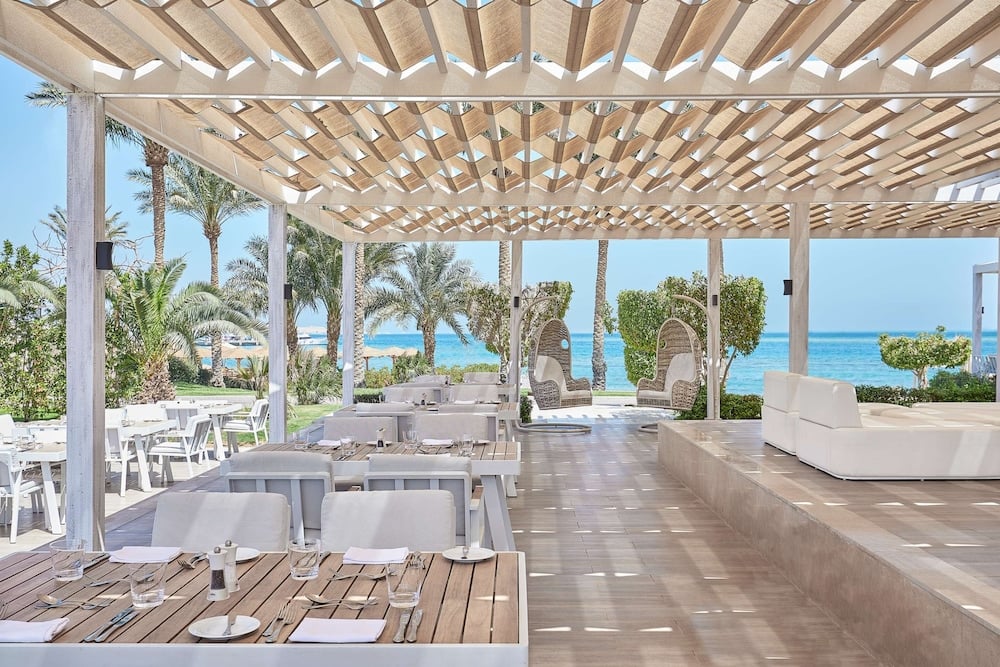 Steigenberger Pure Lifestyle (Adults Only) restaurant terrace with a pergola roof and sea view.