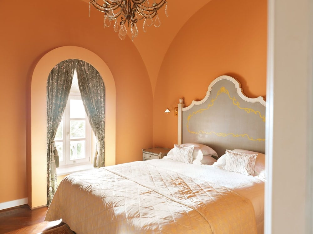La Maison Bleue El Gouna bedroom with an arched window and ornate headboard.
