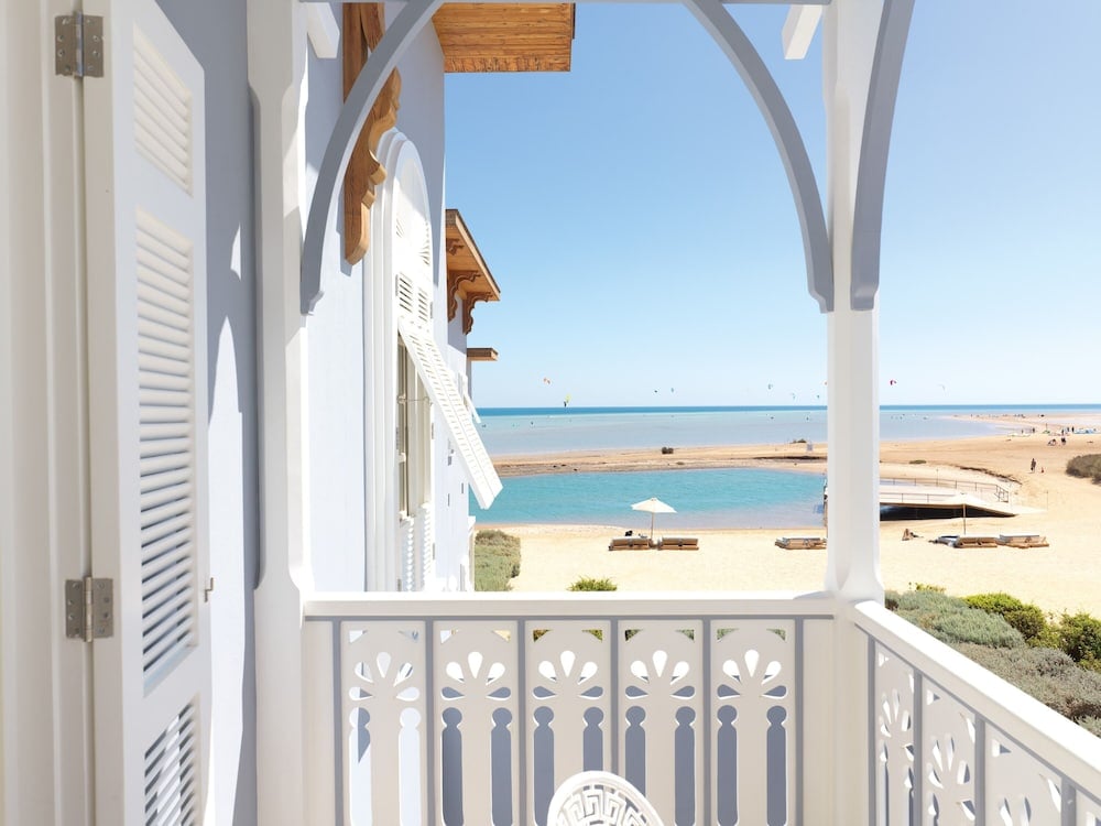 La Maison Bleue El Gouna balcony with an arched white railing and turquoise water.