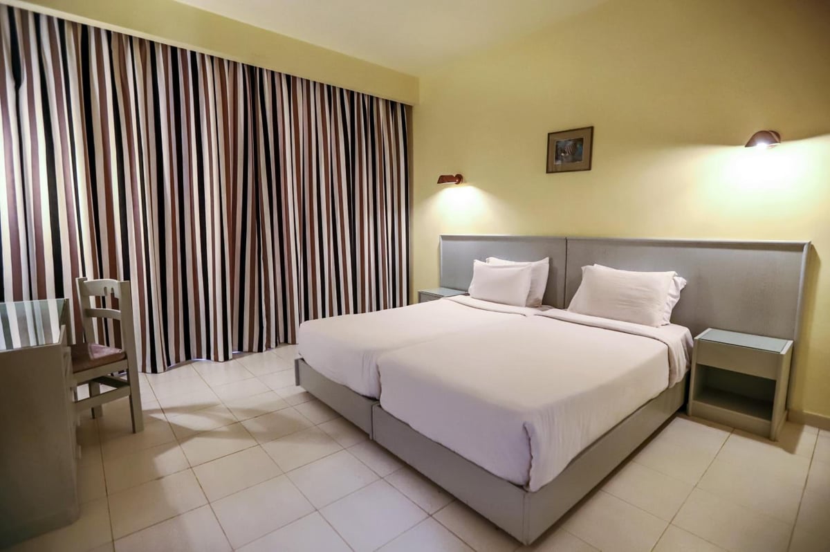 Sunny Days Mirette Family Resort bedroom with twin beds and striped curtains.