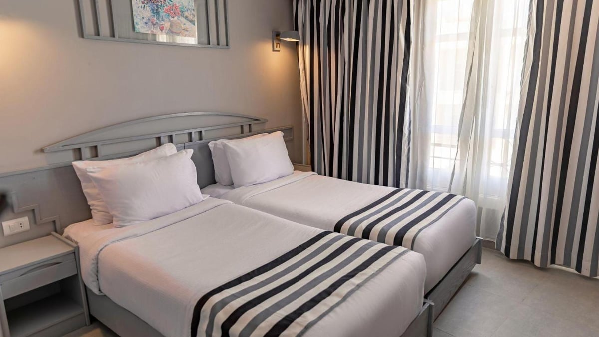 Sunny Days Mirette Family Resort twin bedroom with two beds and striped curtains.