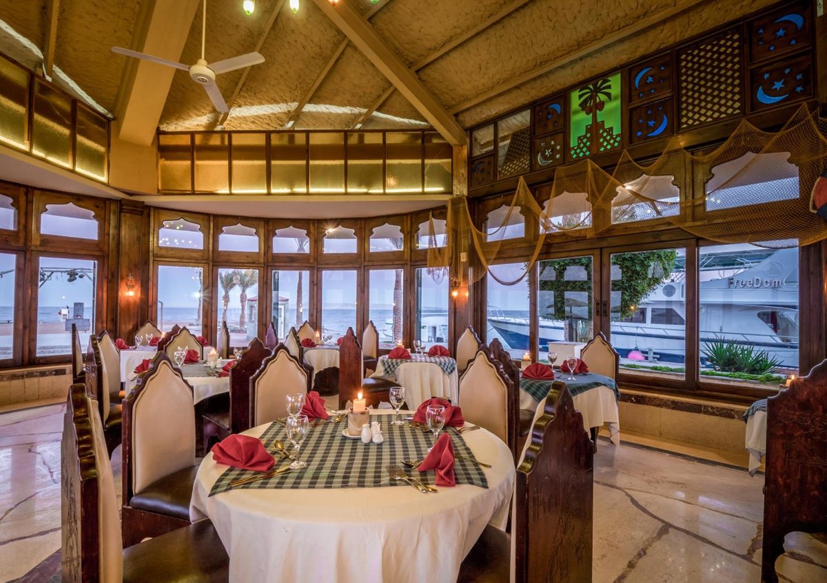 Sunny Days Mirette Family Resort dining room with round tables and large windows.