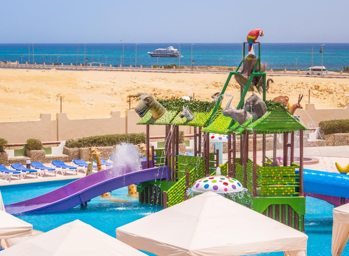 Sunny Days Mirette Family Resort water play area with a green play structure and slides.