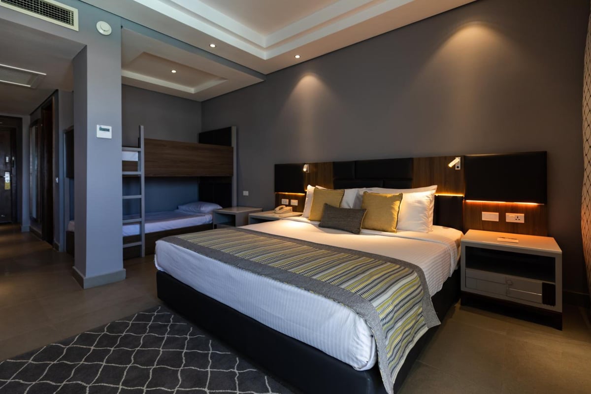 Sunrise Diamond Beach Resort Grand Select bedroom with a king bed and bunk beds.