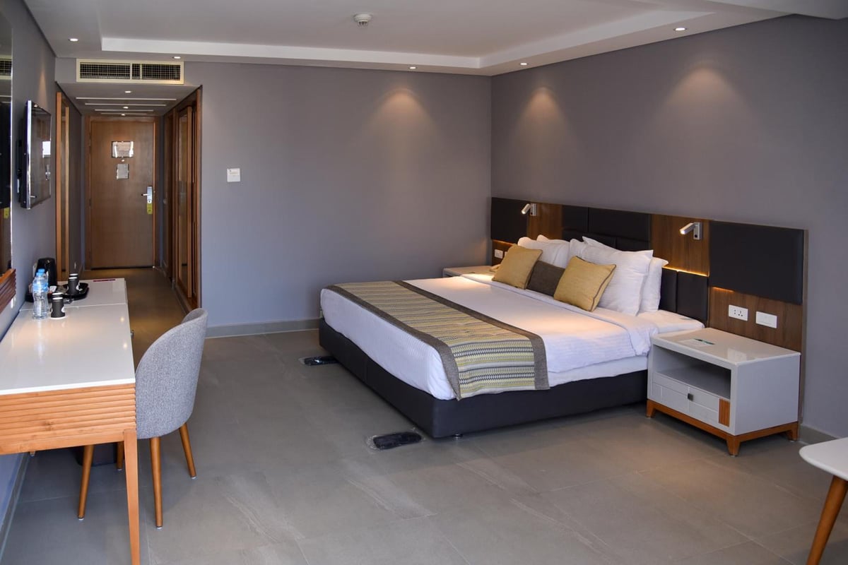 Sunrise Diamond Beach Resort Grand Select guest room with a large bed and desk.