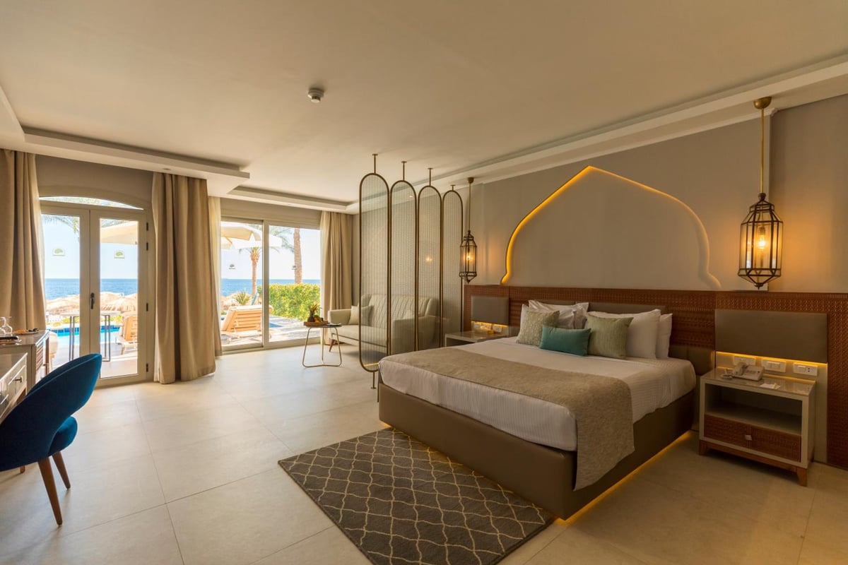 Sunrise Diamond Beach Resort Grand Select bedroom with a bed and sea-view balcony.
