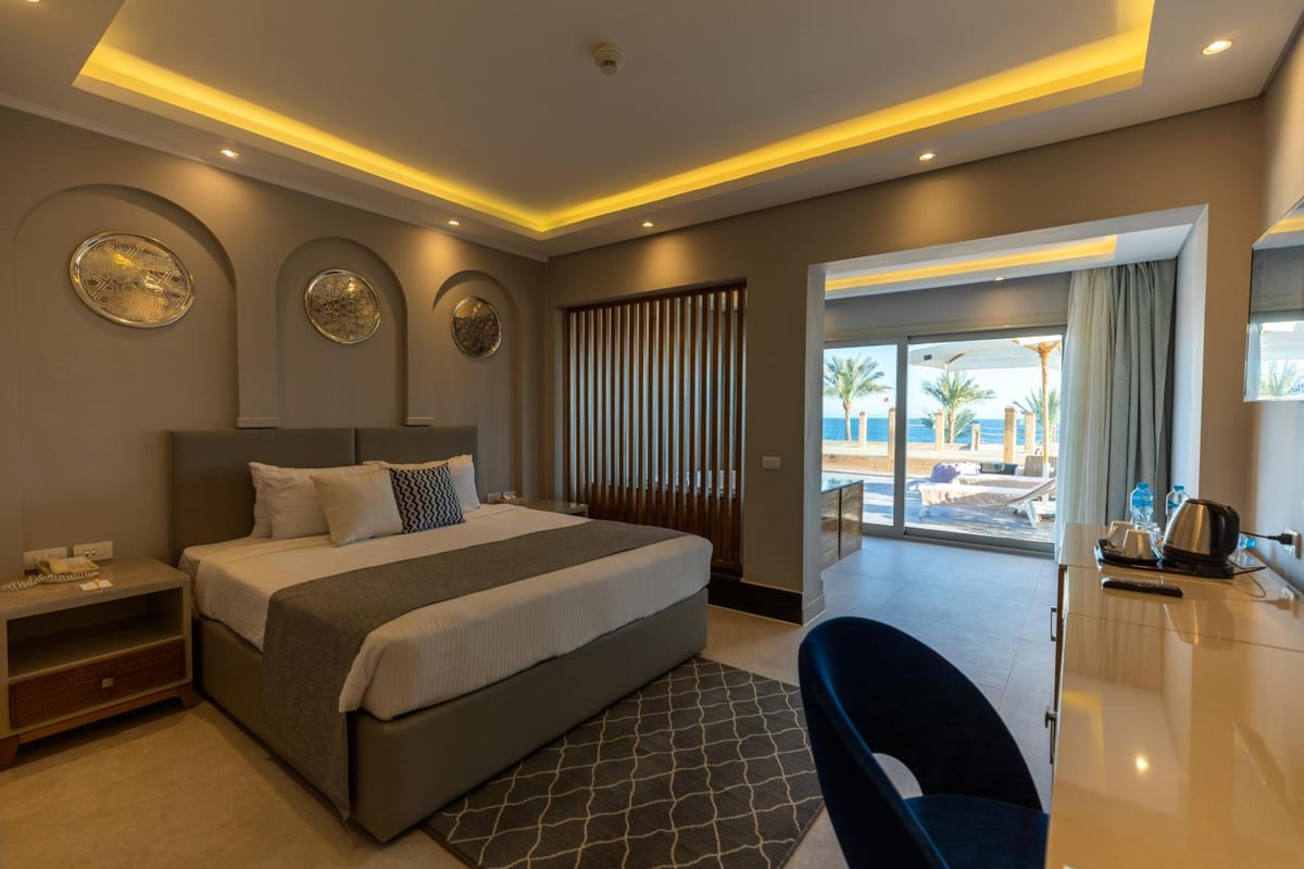 Sunrise Diamond Beach Resort Grand Select guest room with a large bed and sliding glass doors.