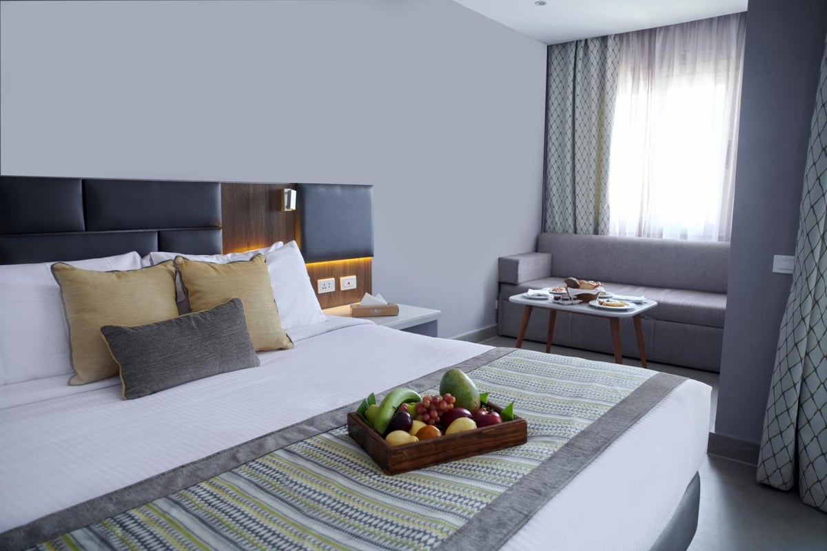 Sunrise Diamond Beach Resort Grand Select guest bedroom with a large bed and window seating.