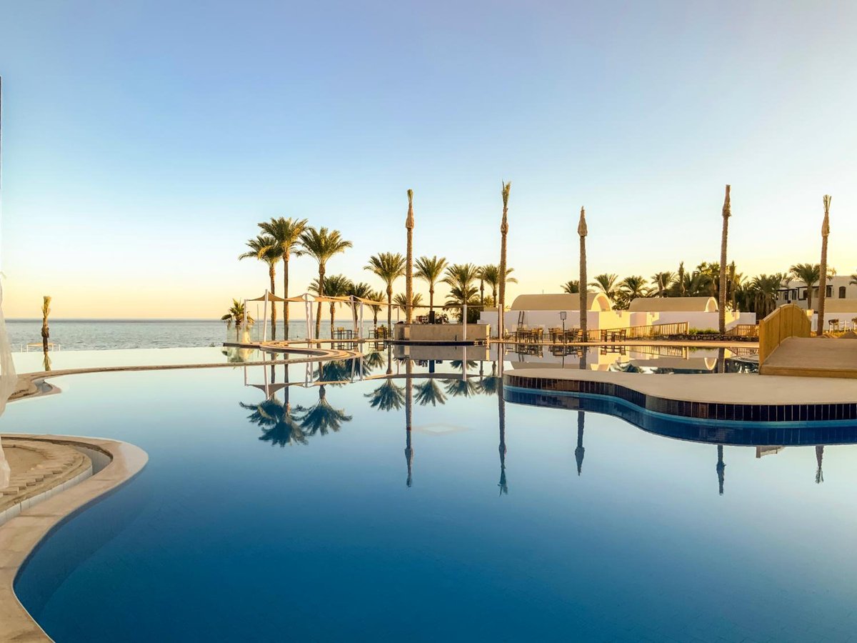 Sunrise Diamond Beach Resort Grand Select pool with palm trees and a sea view.
