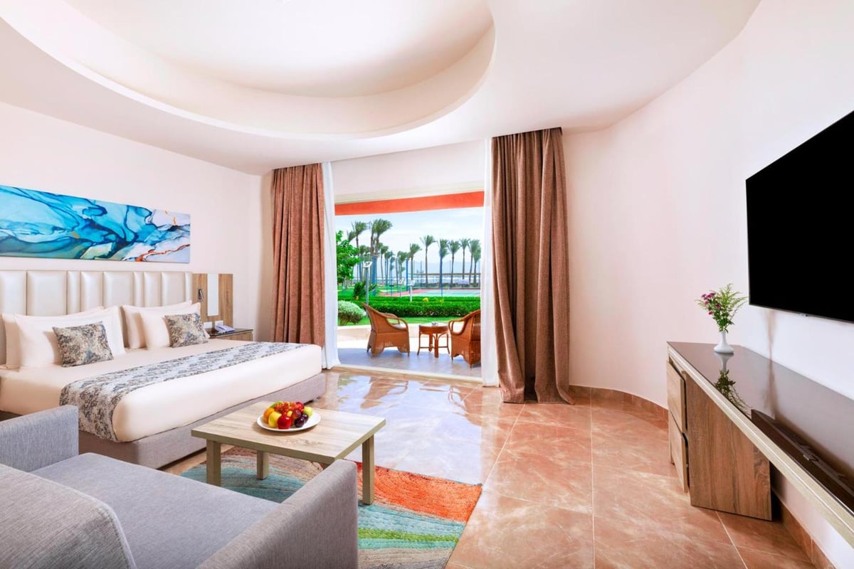 Pickalbatros Laguna Vista Aqua Park bedroom with a large bed and an open balcony.