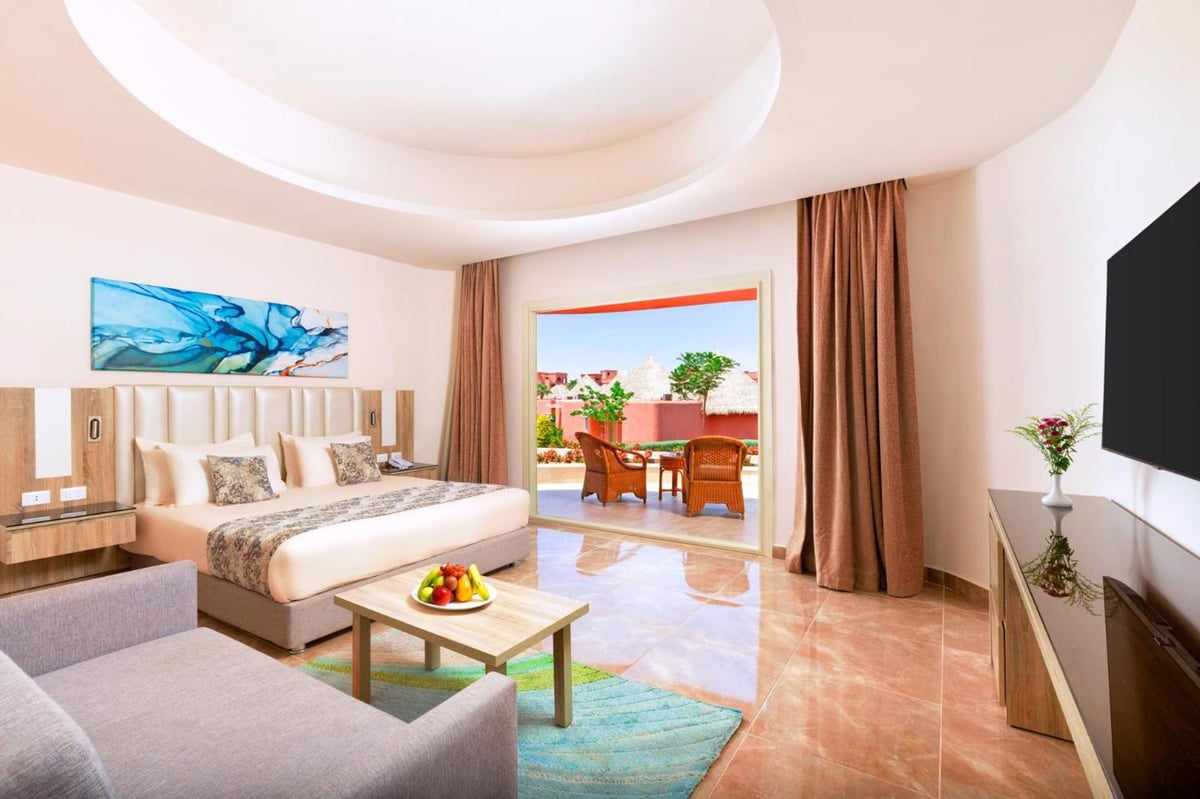Pickalbatros Laguna Vista Aqua Park bedroom with a large bed and open patio doors.