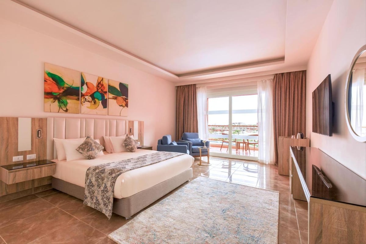 Pickalbatros Laguna Vista Aqua Park guest bedroom with a large bed and sitting area.