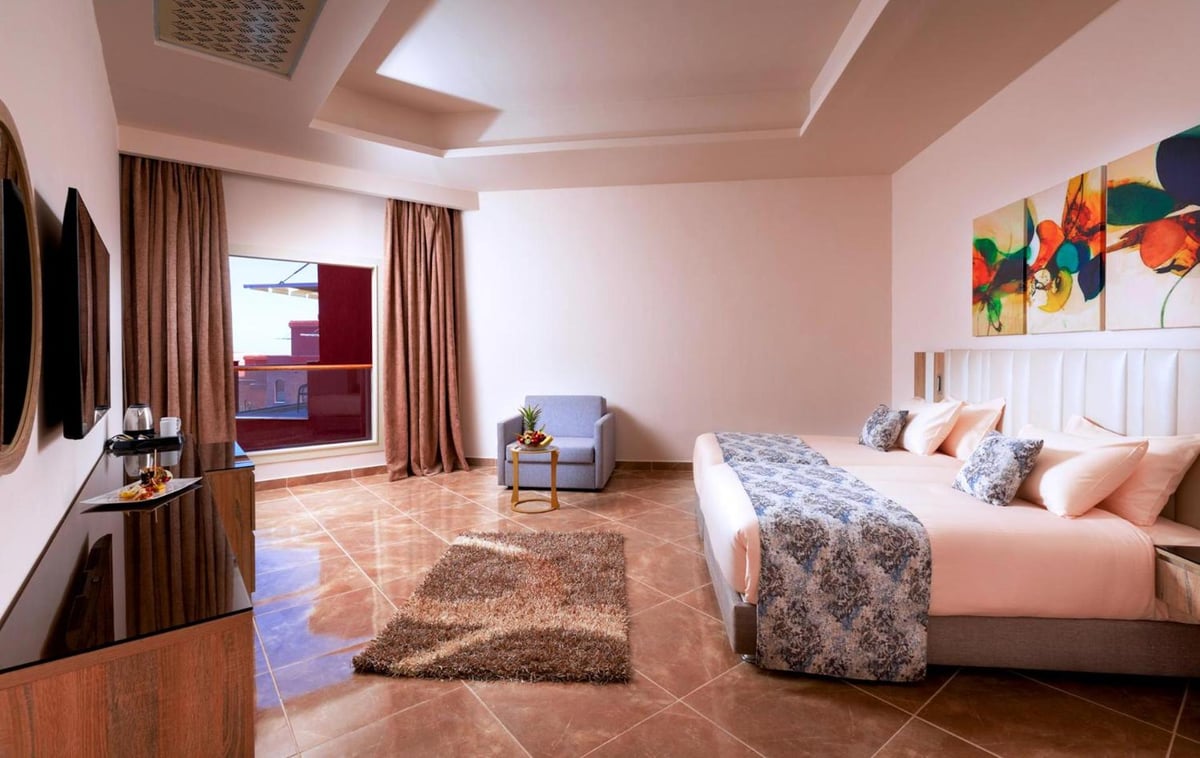 Pickalbatros Laguna Vista Aqua Park bedroom with a large bed and balcony doors.