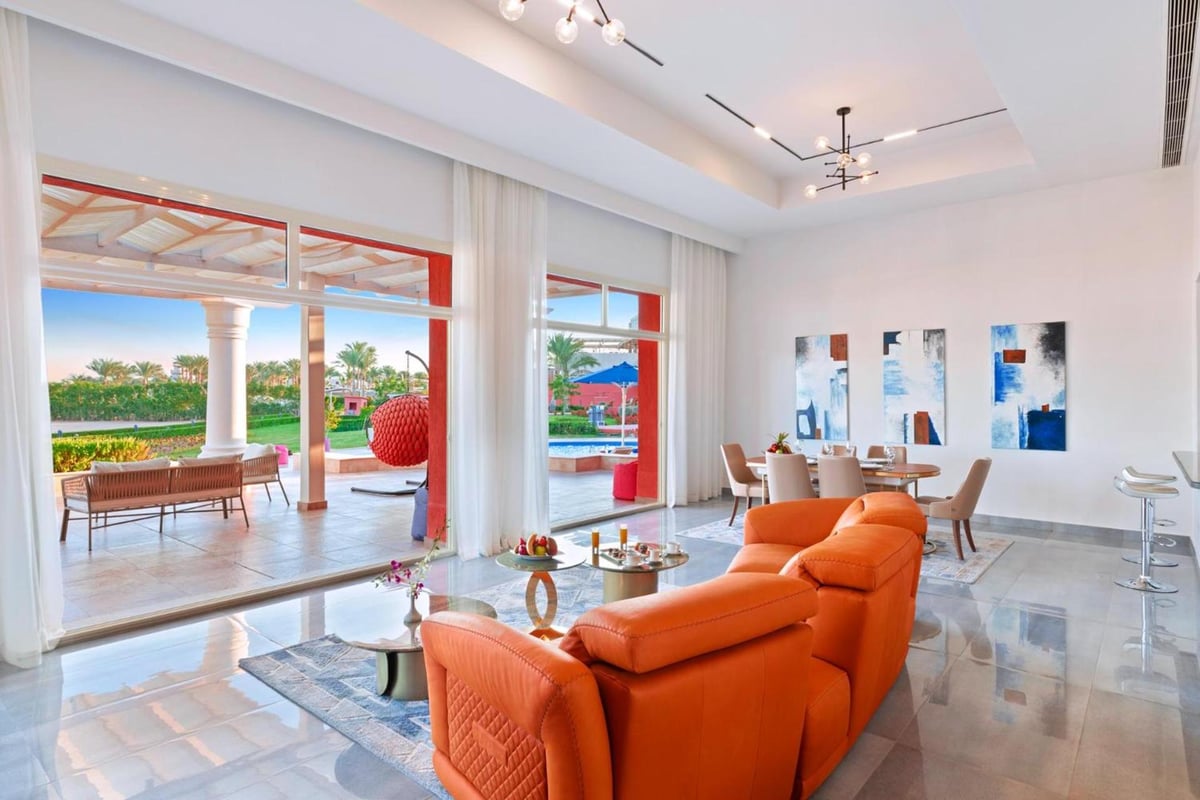 Pickalbatros Laguna Vista Aqua Park lounge with orange sofas and glass doors.