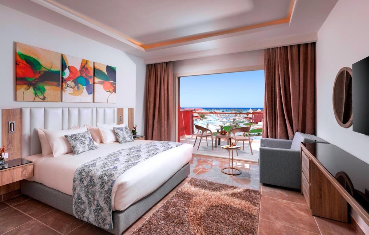 Pickalbatros Laguna Vista Aqua Park bedroom with a bed and balcony.