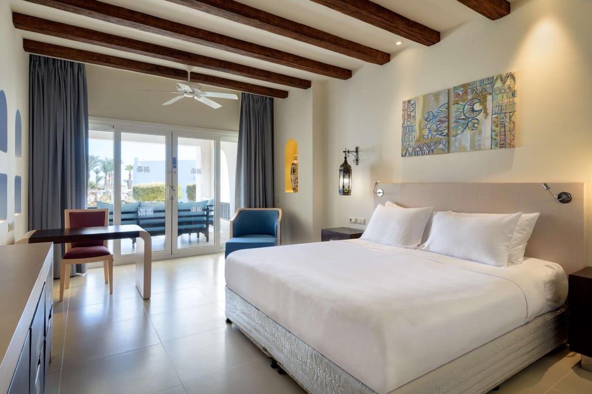 Hilton Marsa Alam Nubian Resort guest room with a large bed and sliding glass doors.