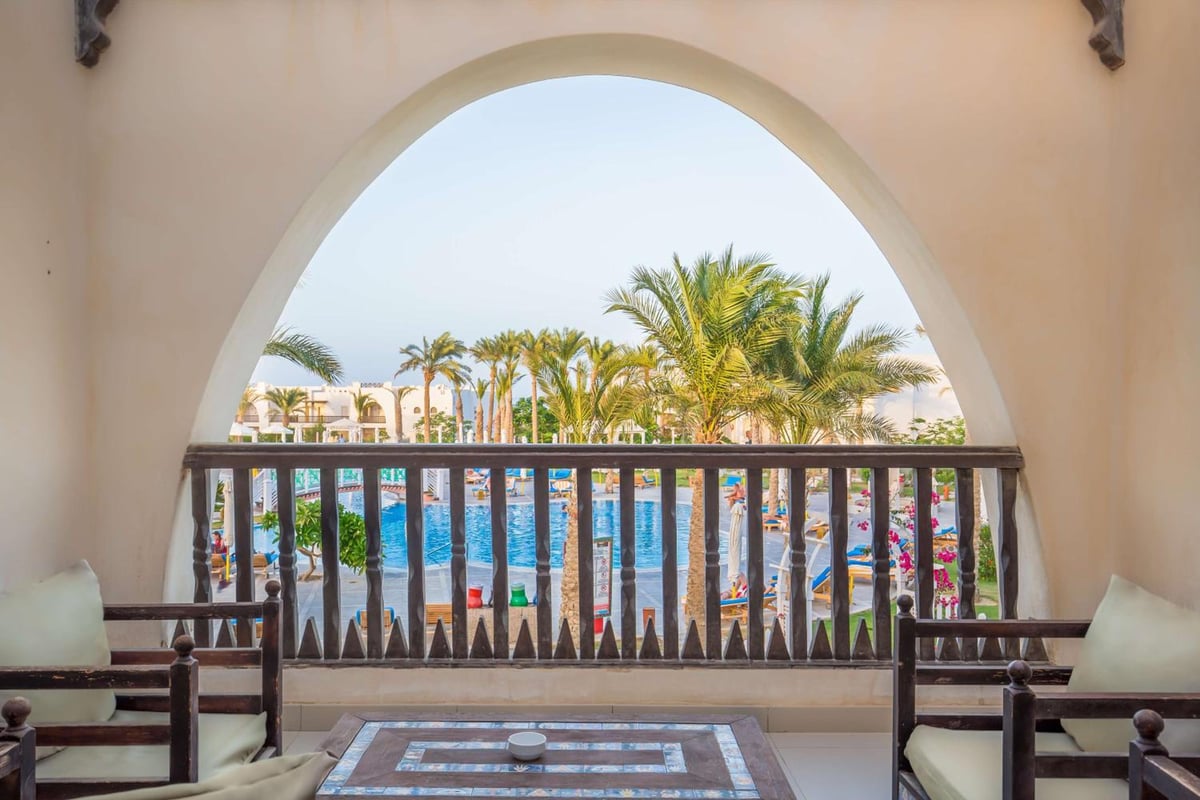 Hilton Marsa Alam Nubian Resort lounge with an arched opening and wooden railing.