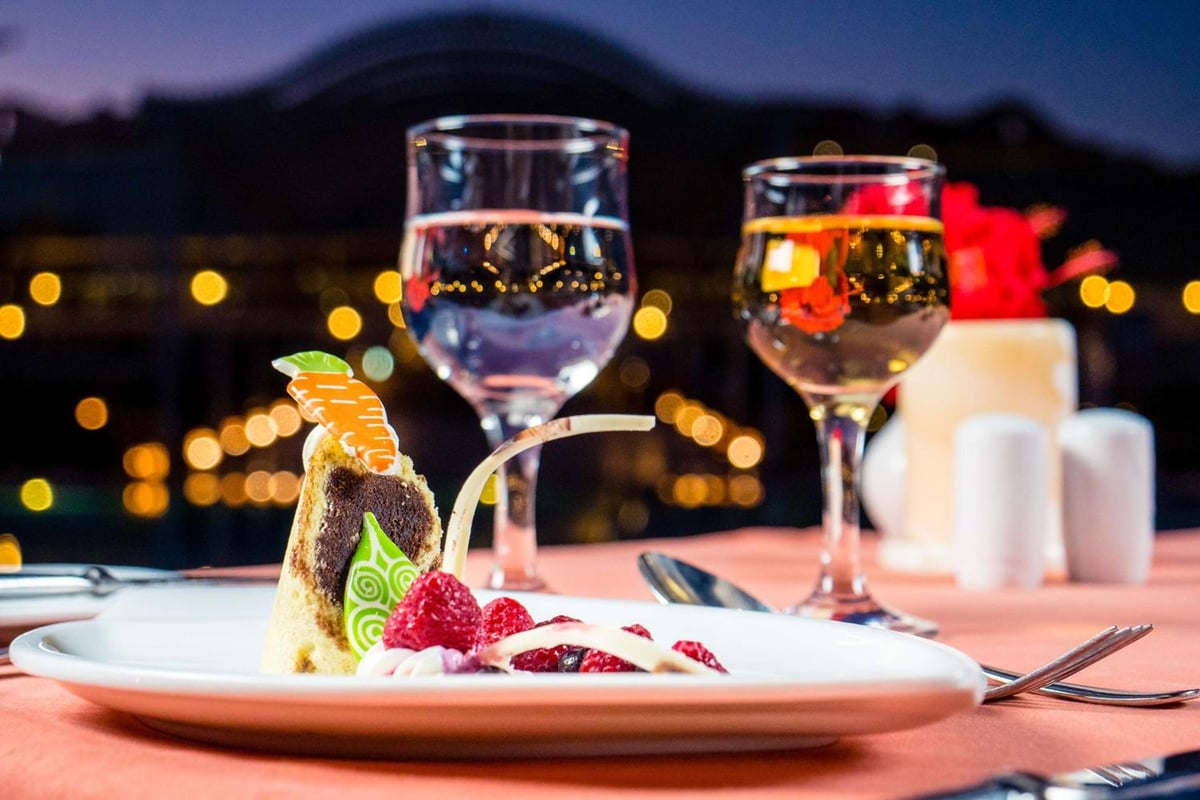 Hilton Marsa Alam Nubian Resort dining table with a plated dessert and stemmed glasses.