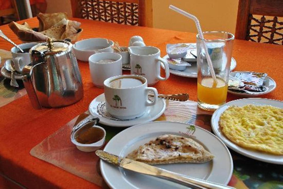 El Nakhil Hotel Luxor dining area with breakfast dishes and an orange tablecloth.