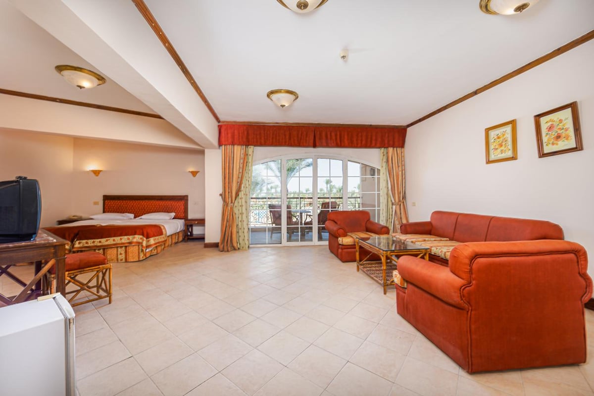 Siva Grand Beach suite living area with sofa seating and sliding glass doors.