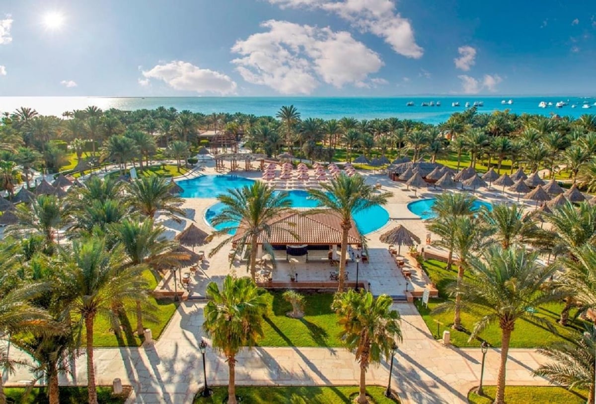 Siva Grand Beach pool area with a winding pool and palm trees.