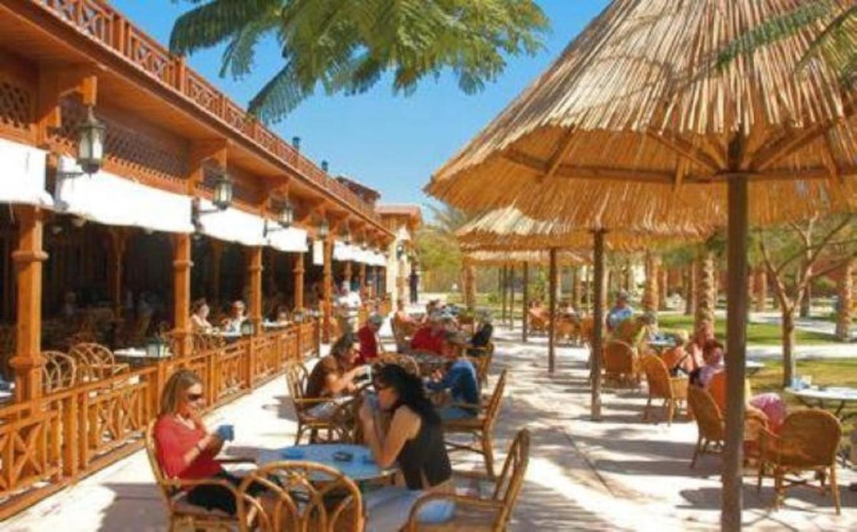 Siva Grand Beach restaurant terrace with a wooden veranda and thatched parasols.