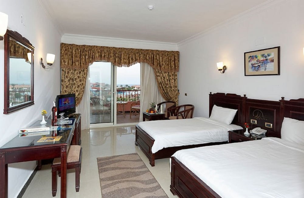 Three Corners Happy Life Beach Resort guest room with twin beds and balcony doors.