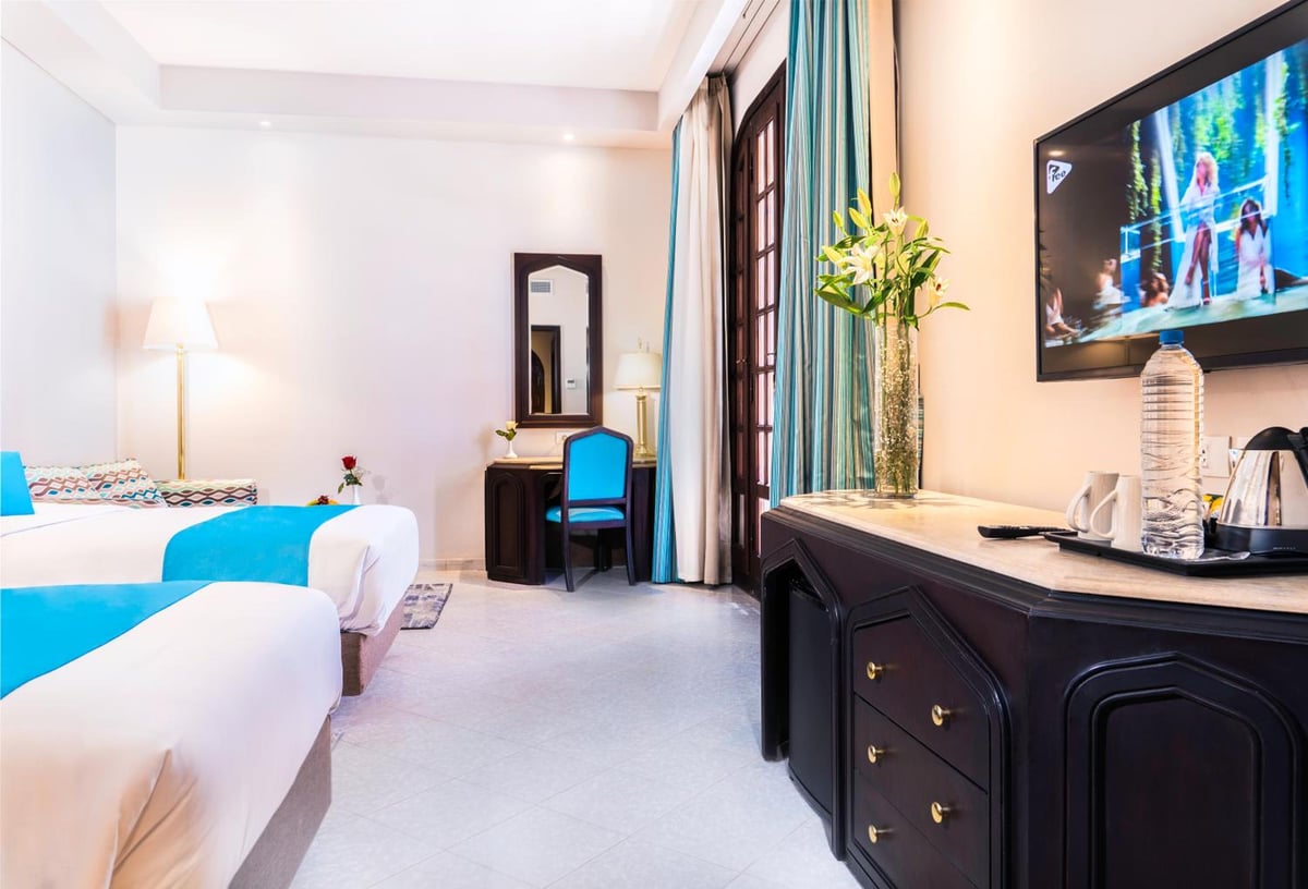 Safir Dahab Resort guest room with twin beds and a wall-mounted television.