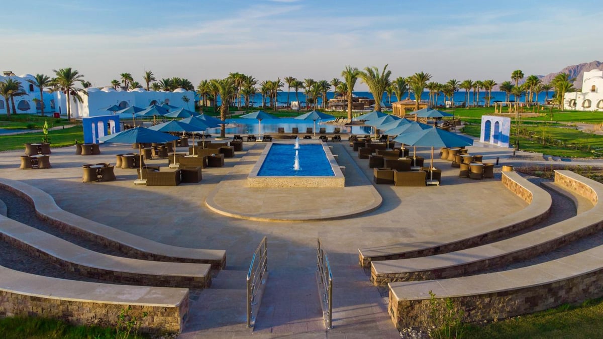 Safir Dahab Resort pool area with a rectangular pool and curved tiered seating.
