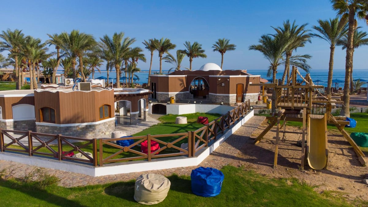 Safir Dahab Resort playground with a wooden climbing frame and yellow slide.