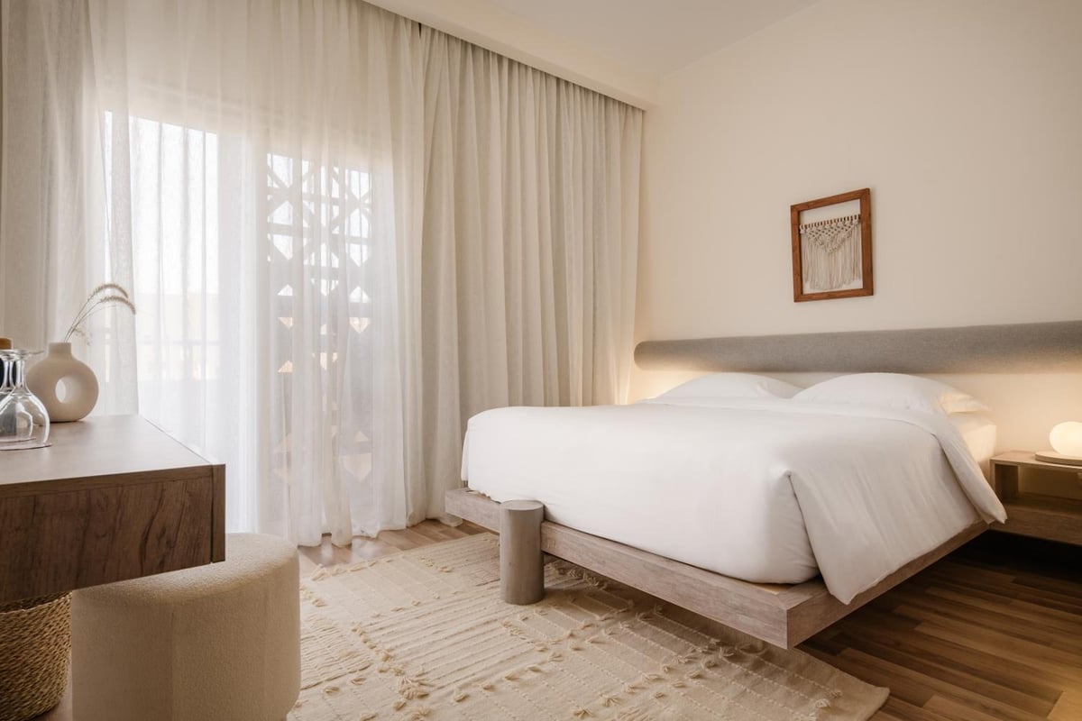 The Zen Wellness Resort Aswan bedroom with a white bed and sheer curtains.