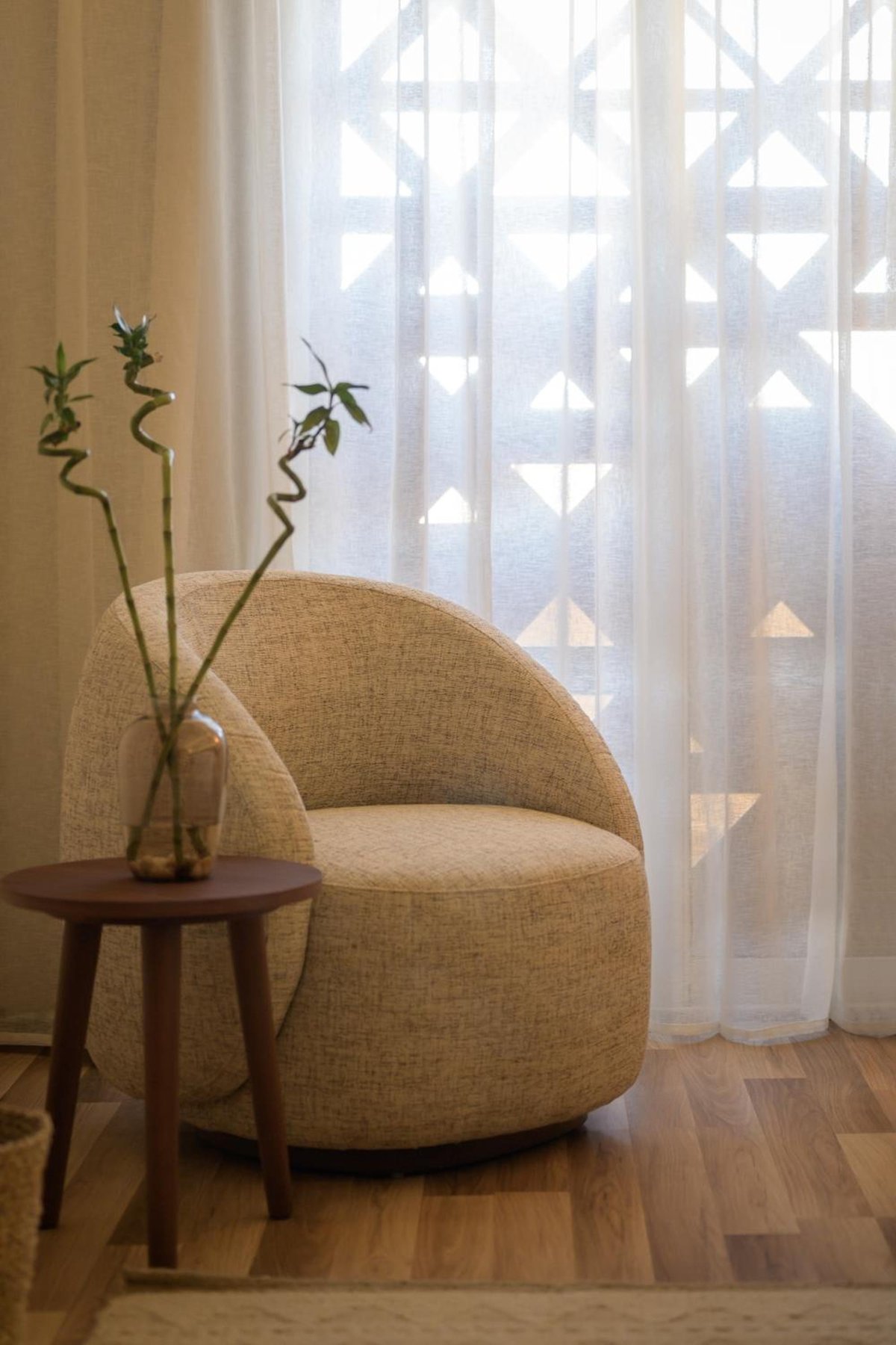 The Zen Wellness Resort Aswan seating area with a rounded armchair and sheer curtains.