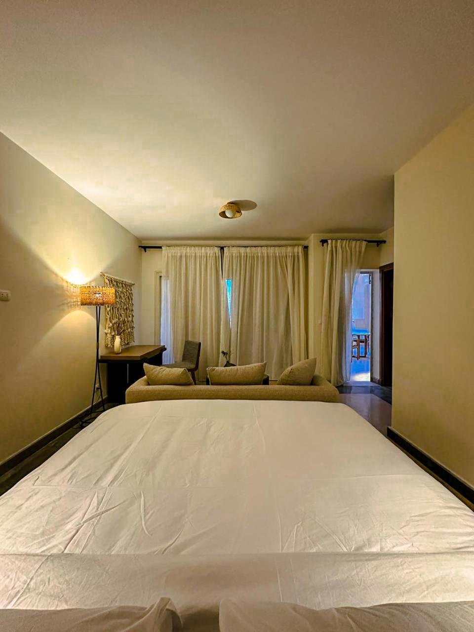 The Zen Wellness Resort Aswan bedroom with a large bed and a sitting area.