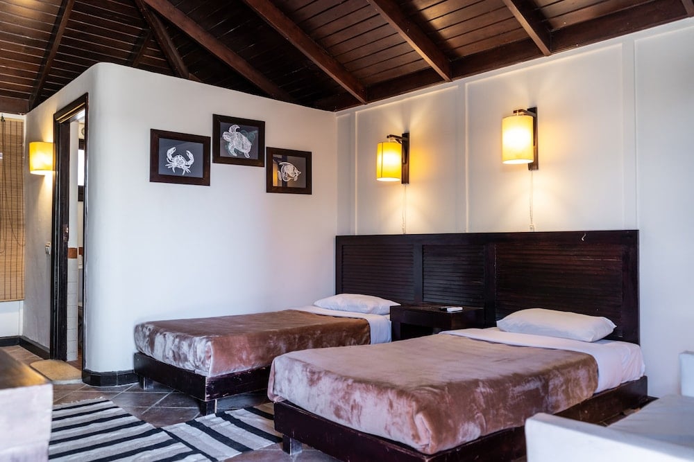 Abu Dabbab Lodge twin bedroom with two beds and a wooden ceiling.