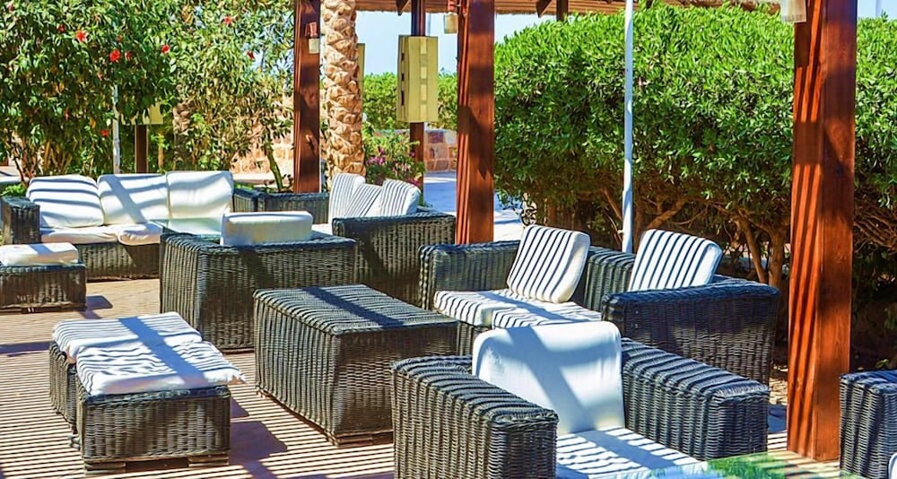 Abu Dabbab Lodge patio lounge with woven seating and striped cushions.
